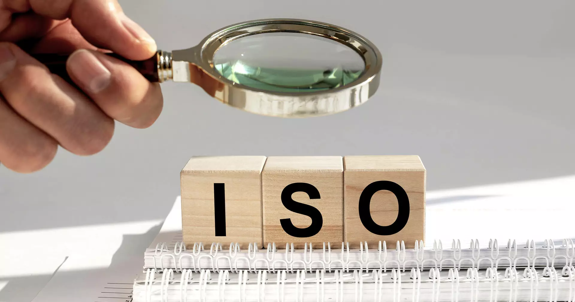 Wooden blocks with the letters "ISO" under a magnifying glass