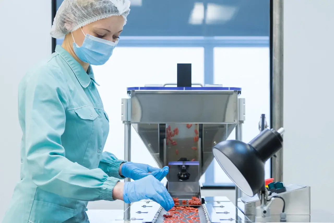 Assembly line in medical technology Employee at an assembly line with tablets