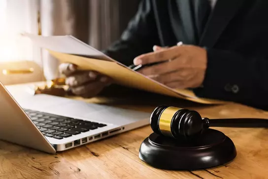 Judge's gavel and laptop on a desk