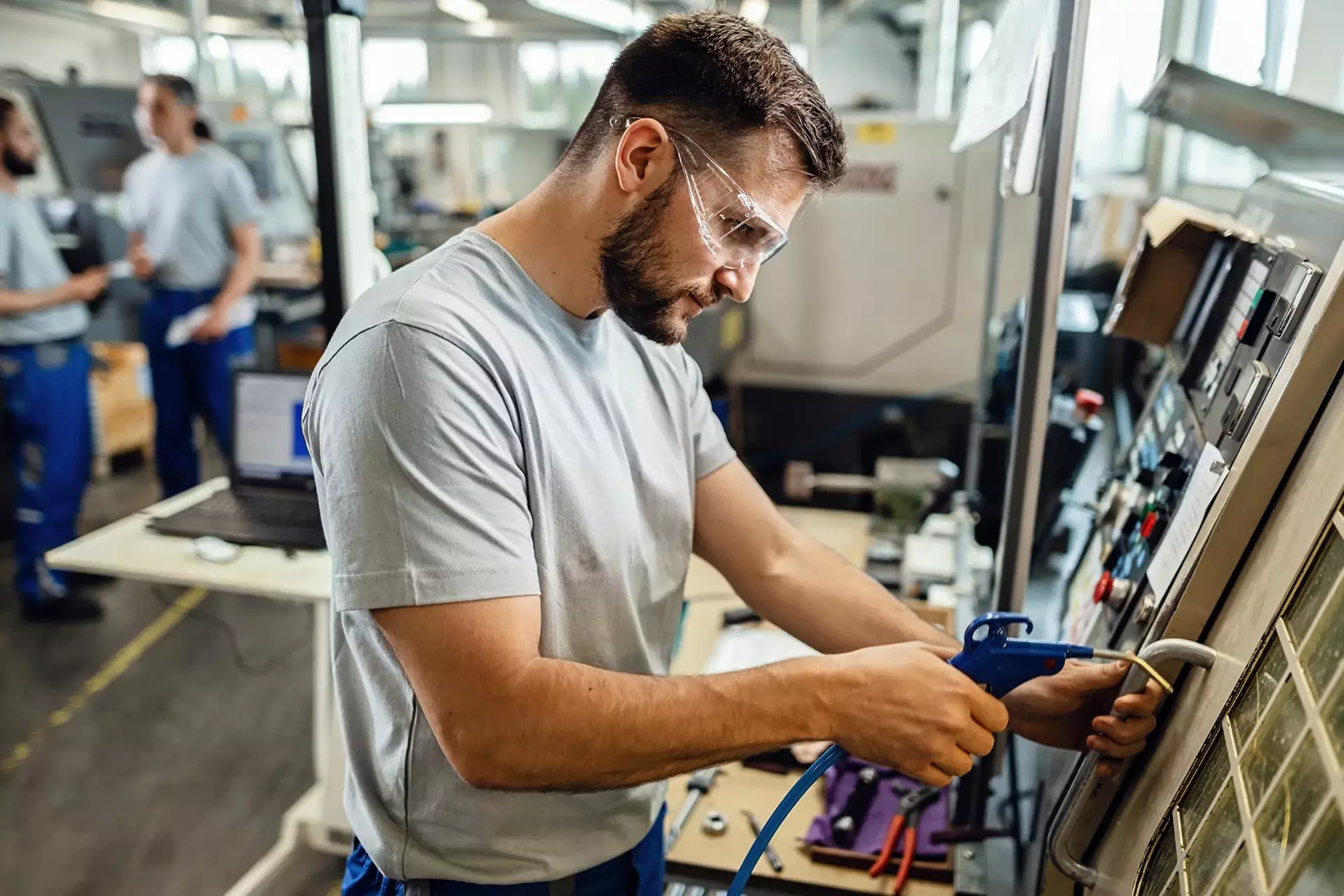 QM employee at a machine in the production hall