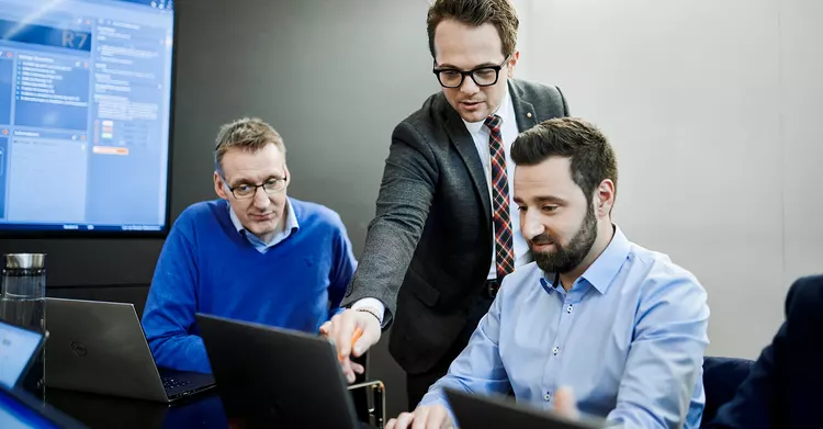 Three Babtec employees discussing something on the laptop