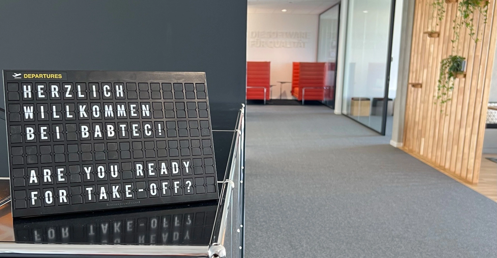 Eingangsbereich des Frankfurter Büros mit Buchstabentafel "Herzlich willkommen bei Babtec. Are you ready for Take-off?"