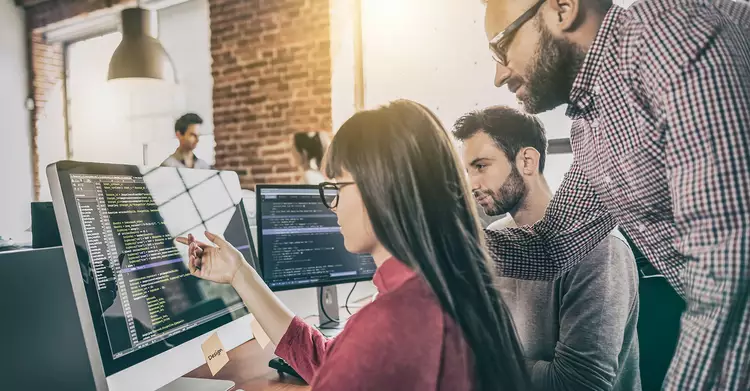 Employees work together on one computer