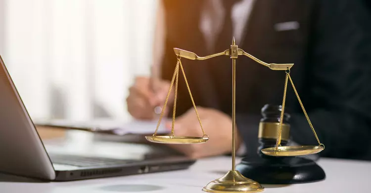 Scales, laptop and judge's hammer on a desk