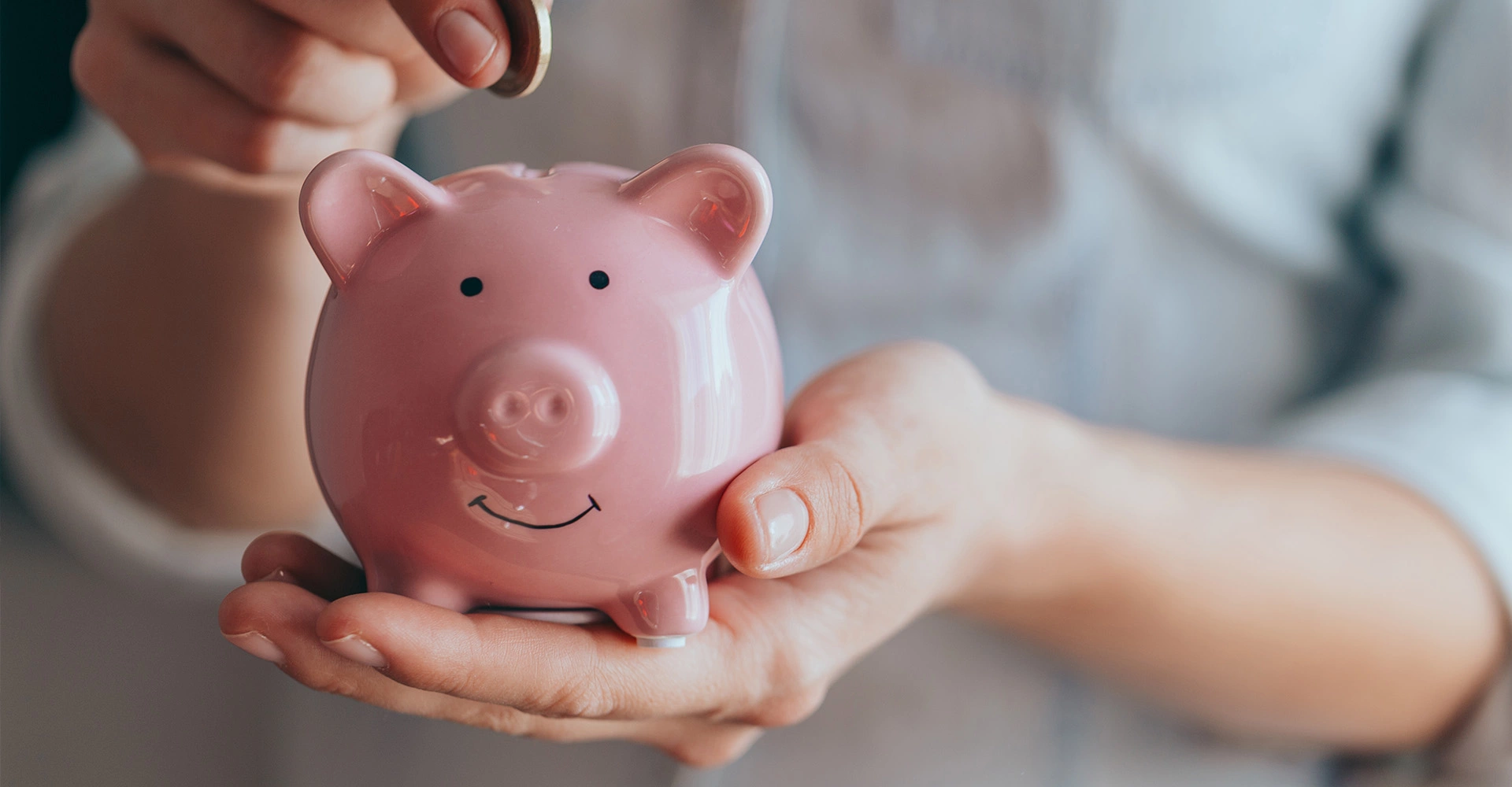 Man throws coin into a piggy bank